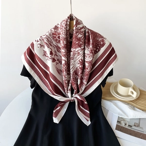 Detailed view of luxury red and white Toile de Jouy pattern silk scarf tied on a black dress