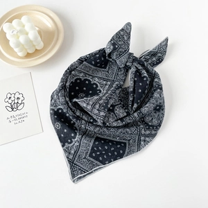 Close-up of classic black and white paisley cotton square scarf used as a stylish headband