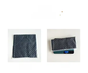Detail view of navy blue patterned square silk scarf with 82g weight on a scale