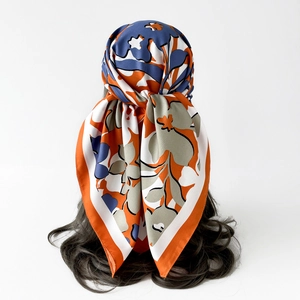 Vue détaillée d'un foulard en soie à fleurs abstraites stylisé en accessoire de coiffure