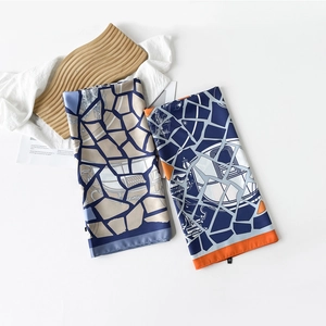 Detail of lightweight twill silk square scarves featuring geometric patterns and neat edges