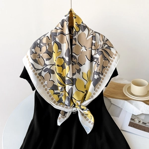 Détail d'un foulard en soie à fleurs noué avec un anneau sur une robe noire
