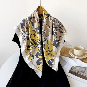 Détail d'un foulard en soie à fleurs jaunes sur une robe noire pour un style élégant