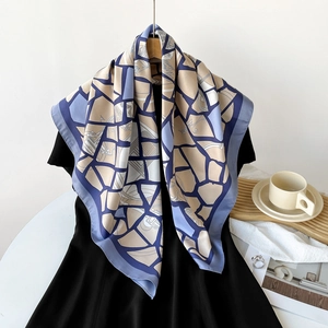 Detail of elegant 90cm square silk scarf featuring geometric mosaic patterns in blue and beige