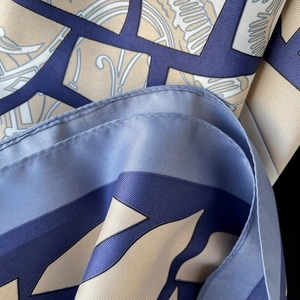 Elegant diagonal twill silk scarf featuring geometric patterns in navy blue and beige colors