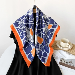 Detail of a large silk-feel square scarf with geometric color block patterns and orange border