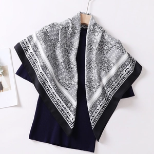 Detailed close-up of 90cm silk scarf with black and white mandala patterns on a hanger