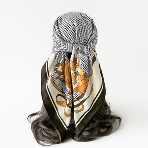 Detail of silk-feel scarf with houndstooth and floral print worn on a styling model