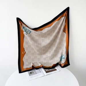 Detail of elegant houndstooth square scarf featuring blue floral corners and orange borders