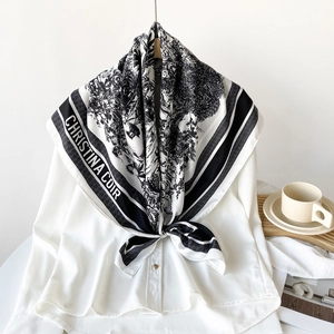 Detail of a black and white silk scarf with French toile print tied on a white shirt collar