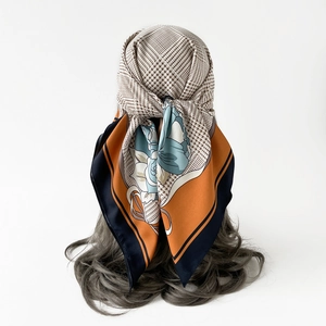 Detail of silk scarf with houndstooth and floral print worn as elegant hair accessory
