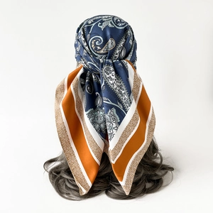 Detailed back view of a paisley silk scarf tied on hair featuring navy and orange patterns