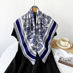 Close-up of blue paisley silk scarf with vintage patterns on a white background