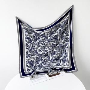 Detailed view of the navy blue paisley silk scarf with satin luster and soft texture