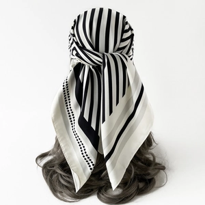 Detail of silk scarf tied as headpiece showing monochrome stripes and polka dot texture
