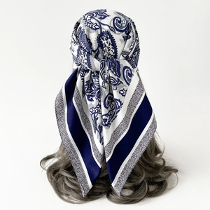 Detail of blue and white paisley silk scarf tied on hair showing soft satin texture