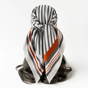 Detailed view of gray and orange striped silk scarf with elegant polka dot patterns