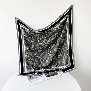 Detail of floral paisley pattern silk scarf with satin finish and black-white texture