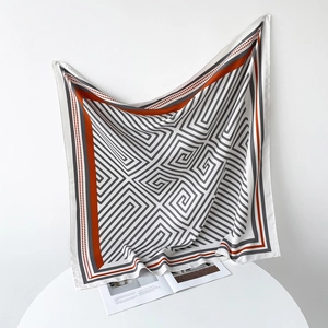 Detail of a 90cm square silk scarf with geometric maze pattern and orange border
