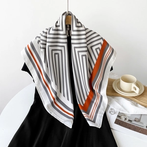 Detail of elegant striped silk scarf draped on black dress with a Parisian cafe setting