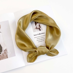 Close-up of champagne gold silk satin scarf tied in a stylish bow knot