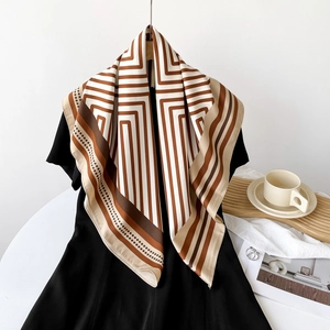 Close-up of lightweight striped silk square scarf in brown and beige with polka dot pattern
