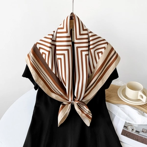 Detail of 90cm striped silk scarf styled with a silver buckle and geometric patterns