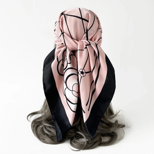 Detail of silk satin scarf with camellia floral print tied on wavy long hair