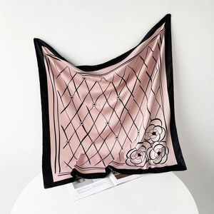 Detail of pink silk scarf featuring black diamond lattice pattern and camellia flowers