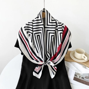 Detailed close-up of striped silk scarf with red dots on a dress for elegant styling