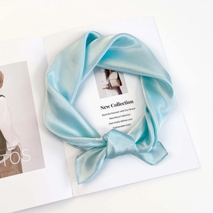 Close-up of light blue satin square scarf with a silky luster on a fashion magazine