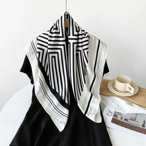 Detail of a large silk scarf with geometric stripes and polka dots on a stylish background