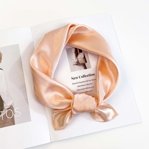 Detail of elegant champagne silk scarf texture with professional stitching and soft luster