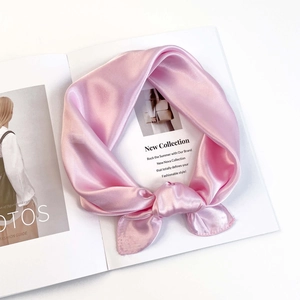 Pale pink satin square scarf tied in a loose knot on a fashion magazine background