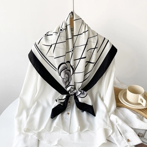 Detail of silk scarf with camellia flower and geometric patterns on a white shirt