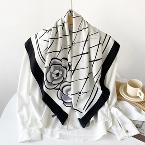 Detail showing elegant black and white plaid silk scarf with camellia print on white shirt