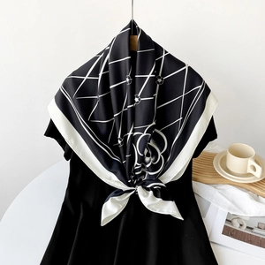 Close-up of silk scarf showing checkered camellia patterns and elegant white borders