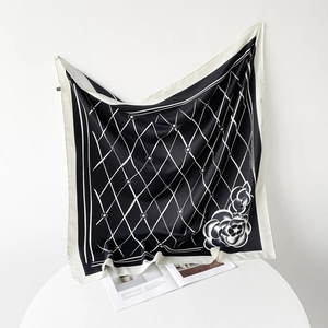 Detailed view of square silk scarf with black white lattice and camellia floral pattern