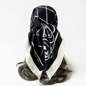Detail shot of silk scarf featuring camellia flowers and grid patterns on wavy hair