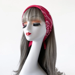 Detailed view of red cotton paisley bandana with classic cashew patterns on model