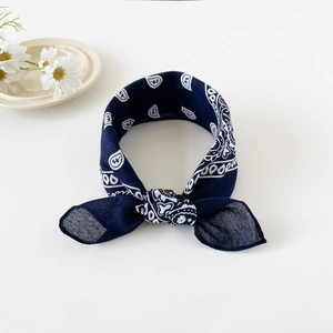 Detail of navy blue paisley bandana showing classic white patterns and neat edge stitching