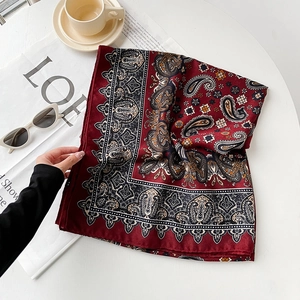 Detailed close-up of dark red paisley cotton linen scarf with elegant floral patterns