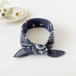 Detail of dark grey cotton paisley bandana tied into a bow for hair styling