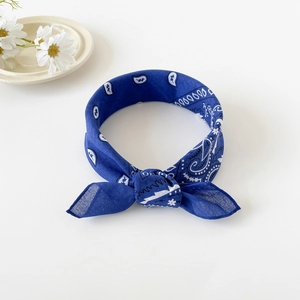 Close-up of knotted dark blue paisley bandana with classic white patterns and daisy decor