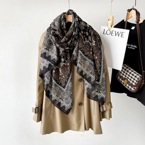 Detail of paisley print linen scarf styled on a trench coat for autumn fashion look