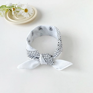 Close-up of a white paisley bandana tied as a headband with daisy floral accents