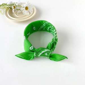 Close-up of a knotted green cotton paisley bandana with classic floral patterns