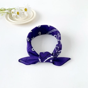 Detailed view of dark purple paisley cotton bandana with a decorative knot detail