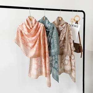 Detail view of cotton-linen scarves with mandala patterns in orange, cyan and brown tones