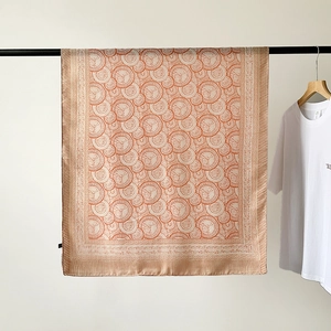 Detail of soft linen-cotton scarf featuring vintage orange floral patterns and striped edges